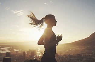 Замотивированная студентка онлайн-школы ТОКИ делает пробежку на фоне солнца